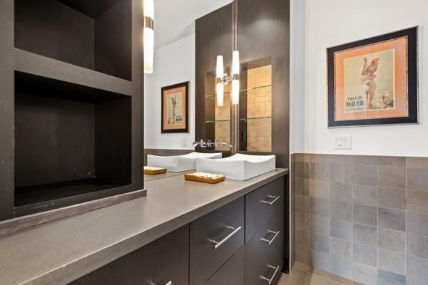 bathroom featuring vanity and tile walls