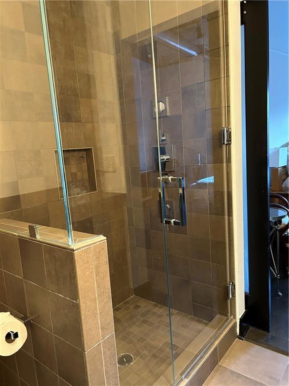bathroom with tile patterned flooring and a stall shower