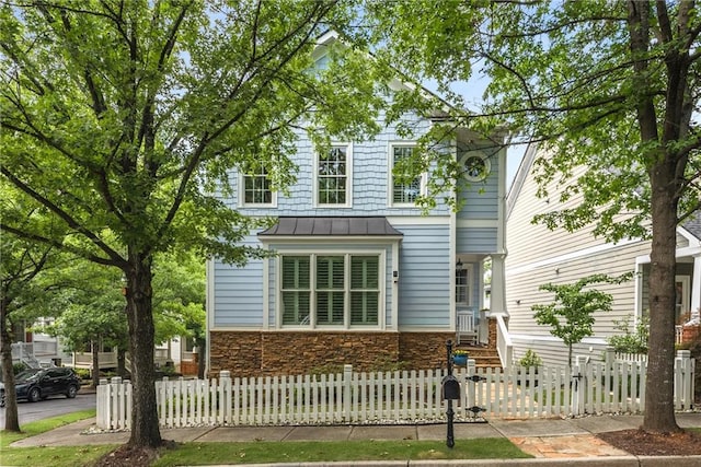 1560 Gilstrap Ln NW, Atlanta, GA 30318 - traditional home with a standing seam roof, stone siding, a fenced front yard, and a metal roof