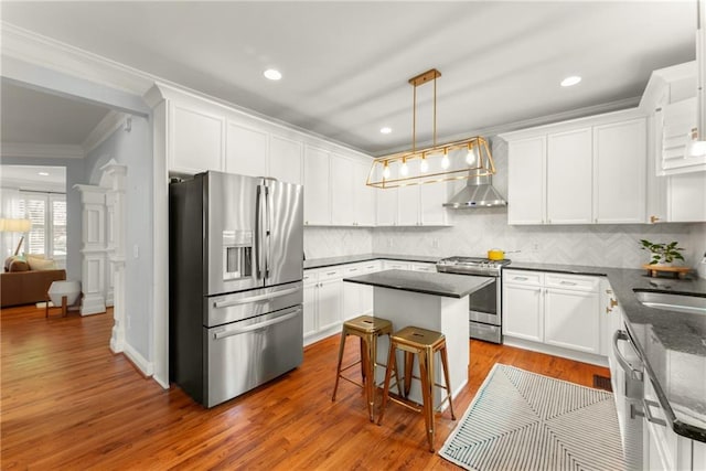 1560 Gilstrap Ln NW, Atlanta, GA 30318 - kitchen featuring appliances with stainless steel finishes, crown molding, white cabinets, a kitchen island, and tasteful backsplash