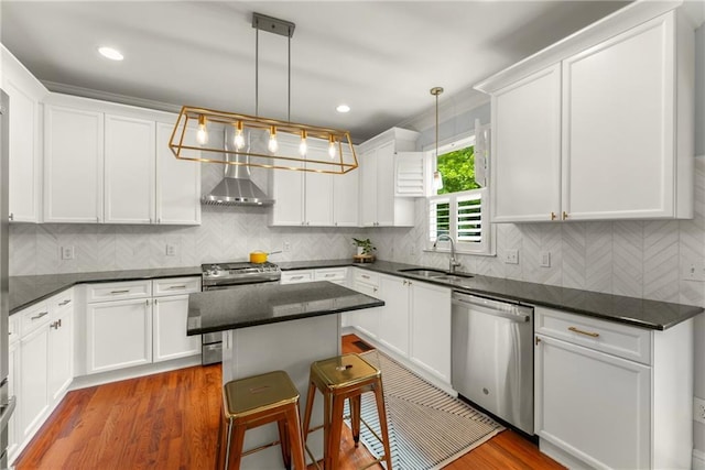 1560 Gilstrap Ln NW, Atlanta, GA 30318 - kitchen with appliances with stainless steel finishes, wall chimney exhaust hood, white cabinetry, a kitchen island, and recessed lighting