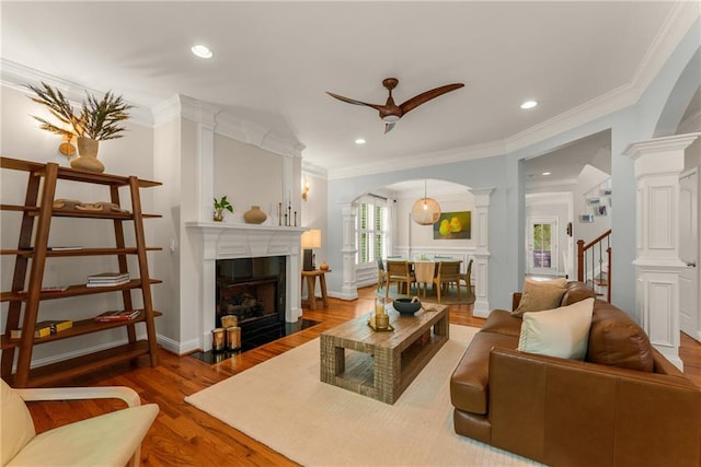 1560 Gilstrap Ln NW, Atlanta, GA 30318 - living room with a fireplace, arched walkways, a ceiling fan, wood finished floors, and crown molding