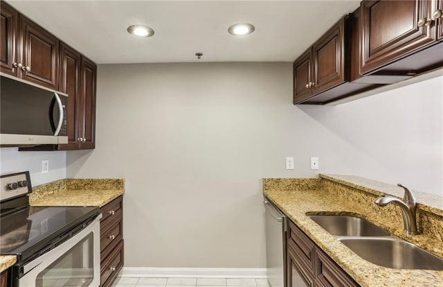 1130 Piedmont Ave NE Unit 410, Atlanta, GA 30309 - kitchen featuring light stone countertops, dark brown cabinets, baseboards, a sink, and stainless steel appliances