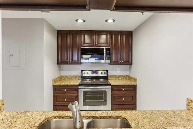 1130 Piedmont Ave NE Unit 410, Atlanta, GA 30309 - kitchen with light stone counters, a sink, appliances with stainless steel finishes, and dark brown cabinetry