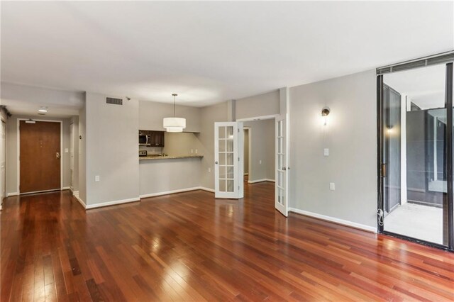 1130 Piedmont Ave NE Unit 410, Atlanta, GA 30309 - unfurnished living room featuring baseboards, visible vents, french doors, and hardwood / wood-style flooring