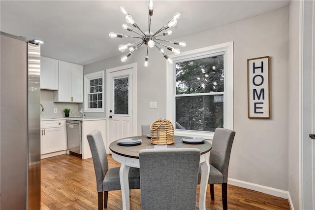 dining space featuring light wood-type flooring and a notable chandelier