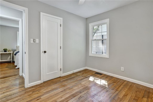 spare room with light wood finished floors, baseboards, and visible vents