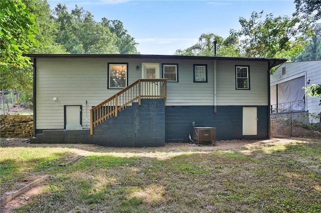 rear view of property with stairway, fence, cooling unit, and a yard