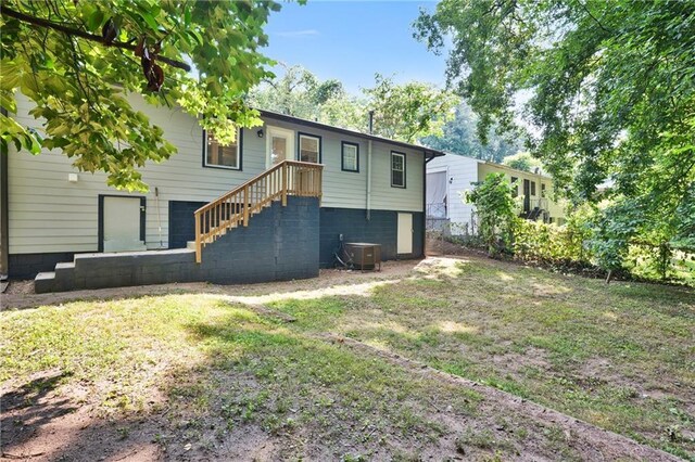 rear view of house featuring a yard and central AC unit