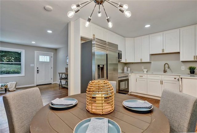 dining space with an inviting chandelier, baseboards, dark wood-type flooring, and recessed lighting