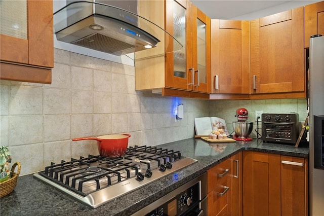 kitchen featuring decorative backsplash, glass insert cabinets, brown cabinets, appliances with stainless steel finishes, and island exhaust hood