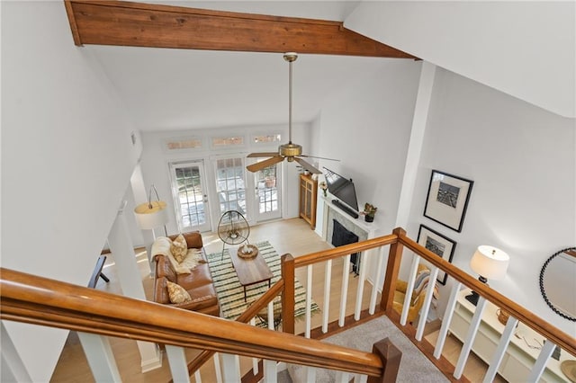 stairway featuring vaulted ceiling with beams, ceiling fan, and a fireplace