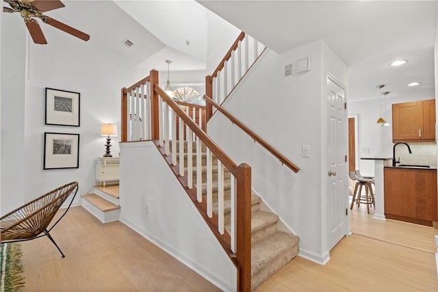 stairs featuring recessed lighting, visible vents, a ceiling fan, wood finished floors, and baseboards