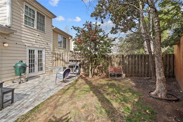 view of yard with a patio area, french doors, and a fenced backyard