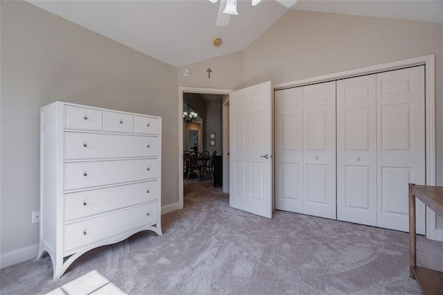 unfurnished bedroom featuring a closet, light colored carpet, ceiling fan, and vaulted ceiling