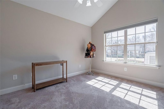 spare room with carpet, lofted ceiling, a ceiling fan, and baseboards