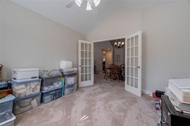 carpeted office space featuring ceiling fan with notable chandelier, french doors, and lofted ceiling