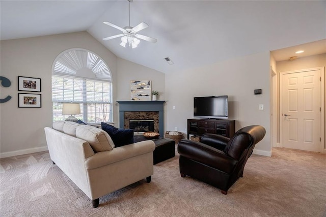 living area featuring visible vents, baseboards, light carpet, a glass covered fireplace, and a ceiling fan