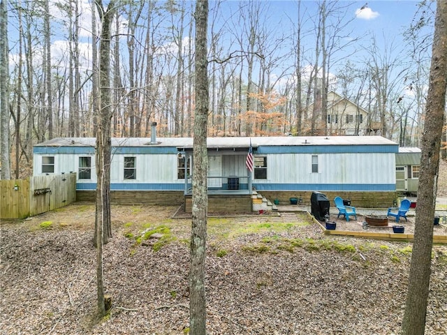 manufactured / mobile home featuring an outdoor fire pit and fence