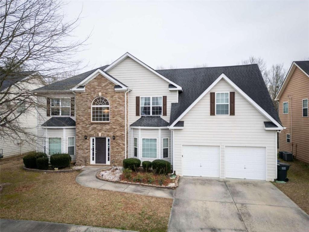 view of property featuring a garage and central AC