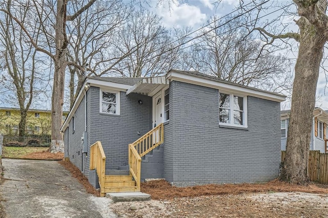 view of front of property with brick siding and fence