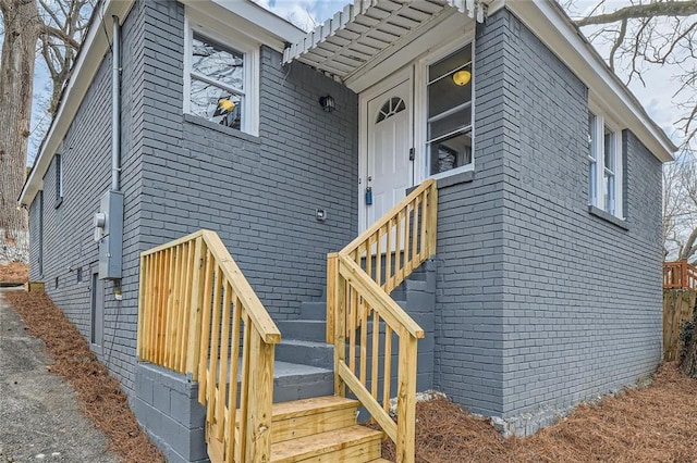 doorway to property featuring brick siding