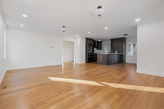 unfurnished living room with recessed lighting, visible vents, baseboards, and light wood-style flooring