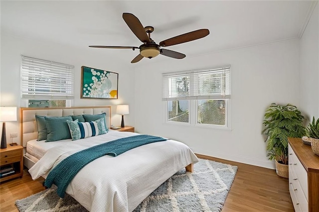 bedroom with light wood-style flooring, baseboards, and ceiling fan