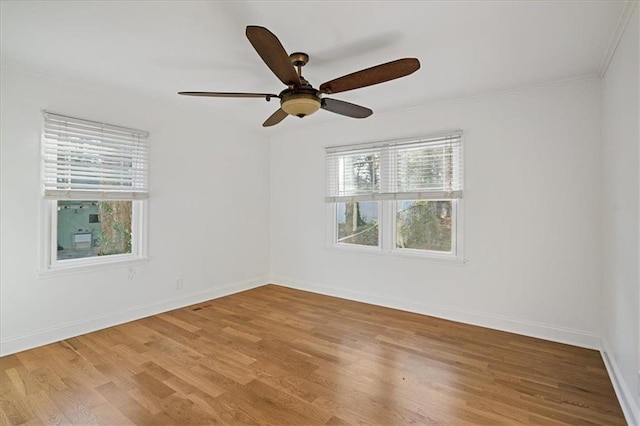 unfurnished room with wood finished floors, baseboards, and ceiling fan