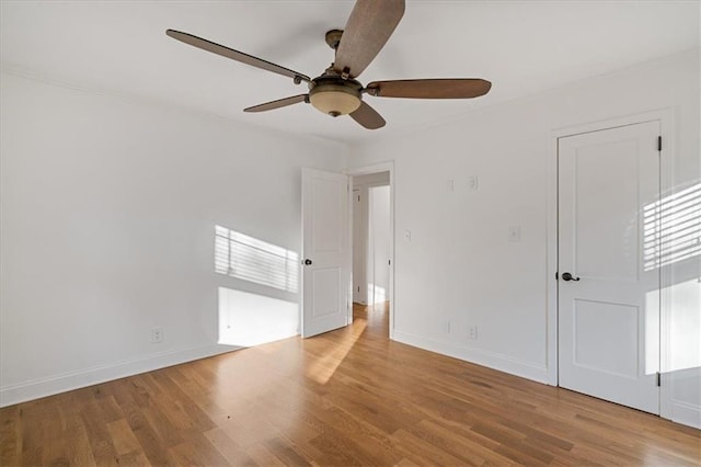 unfurnished bedroom featuring a ceiling fan, wood finished floors, and baseboards