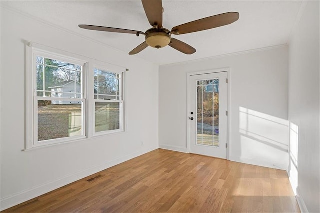 spare room featuring visible vents, baseboards, wood finished floors, and ornamental molding