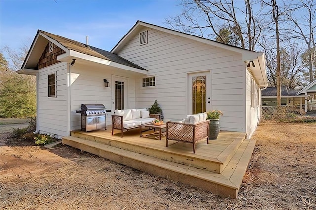 back of house featuring a deck, an outdoor living space, and fence