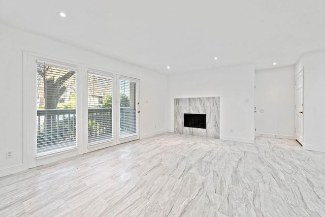 unfurnished living room with recessed lighting, a fireplace, and baseboards