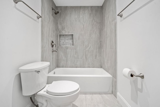 bathroom with baseboards, toilet, and shower / tub combination