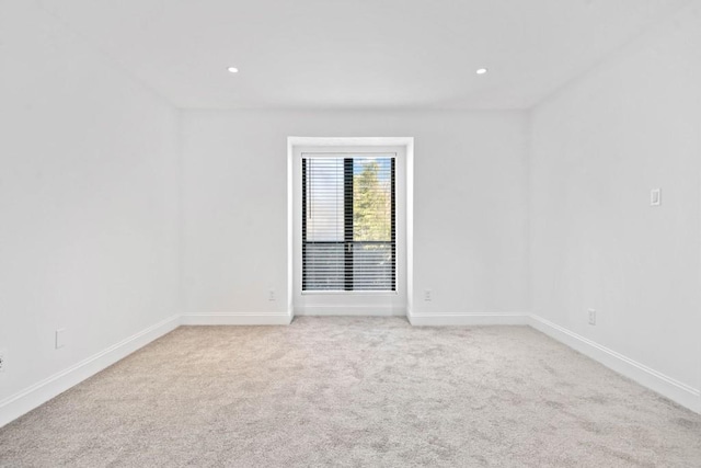 unfurnished room featuring light carpet, recessed lighting, and baseboards