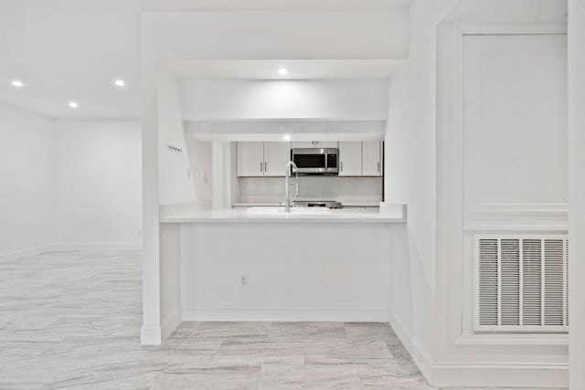 kitchen featuring visible vents, recessed lighting, white cabinets, stainless steel microwave, and backsplash