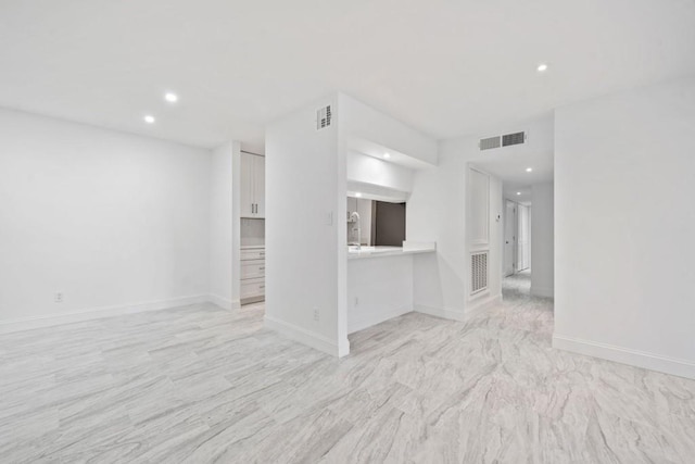 unfurnished living room featuring visible vents, recessed lighting, and baseboards