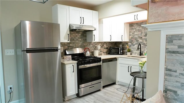 kitchen featuring white cabinetry, appliances with stainless steel finishes, sink, and decorative backsplash