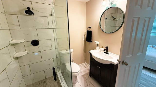 bathroom with tiled shower, vanity, and toilet