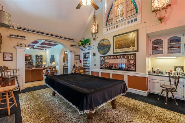 recreation room featuring billiards, ornate columns, high vaulted ceiling, dark colored carpet, and ceiling fan