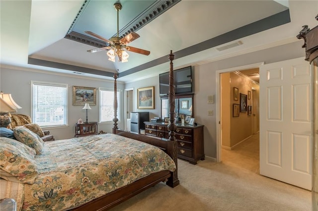 bedroom featuring ceiling fan, light carpet, and a raised ceiling