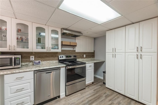 kitchen featuring a paneled ceiling, stainless steel appliances, and white cabinetry