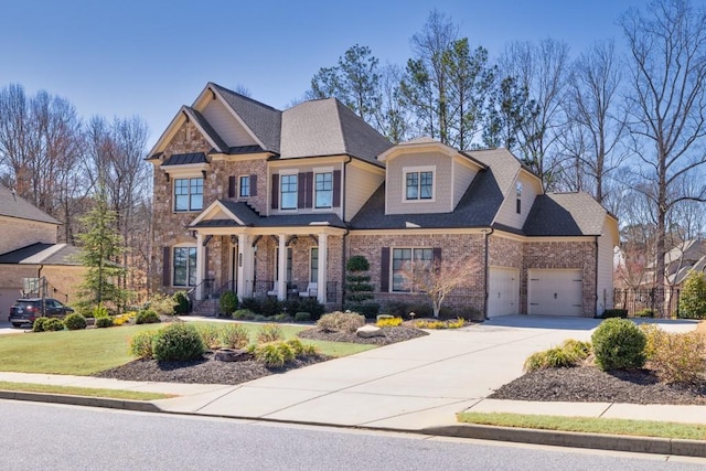 craftsman-style home featuring a garage, brick siding, driveway, roof with shingles, and a front yard