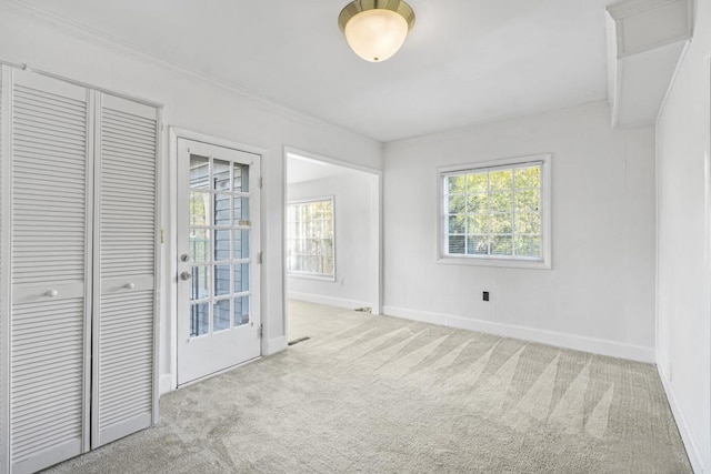 carpeted spare room featuring crown molding