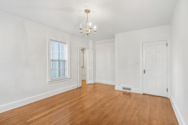 unfurnished room with crown molding, hardwood / wood-style floors, and a notable chandelier