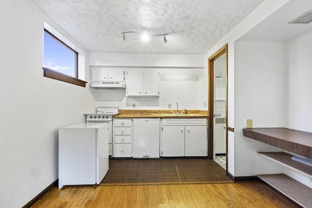 kitchen with white cabinetry, sink, dark hardwood / wood-style flooring, a textured ceiling, and white appliances