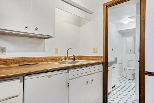 kitchen with white dishwasher, white cabinets, and sink