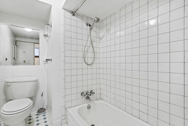 bathroom featuring tile patterned floors, tiled shower / bath combo, and toilet