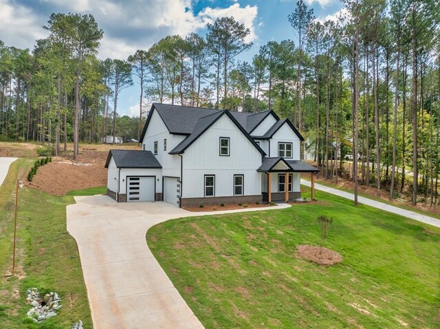 modern farmhouse style home with a front yard and a garage