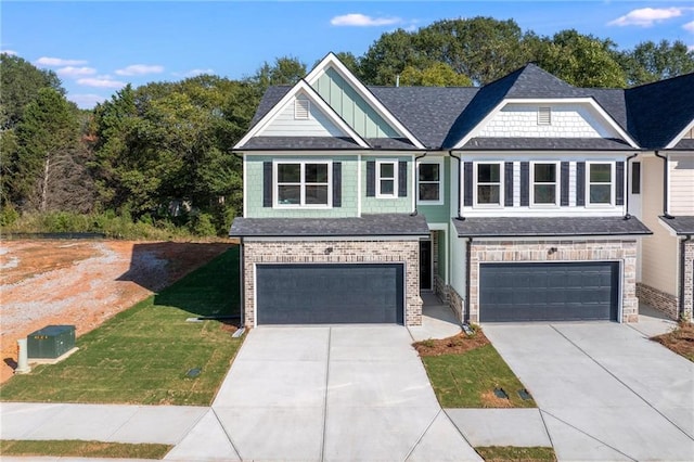 craftsman inspired home featuring a garage and a front lawn